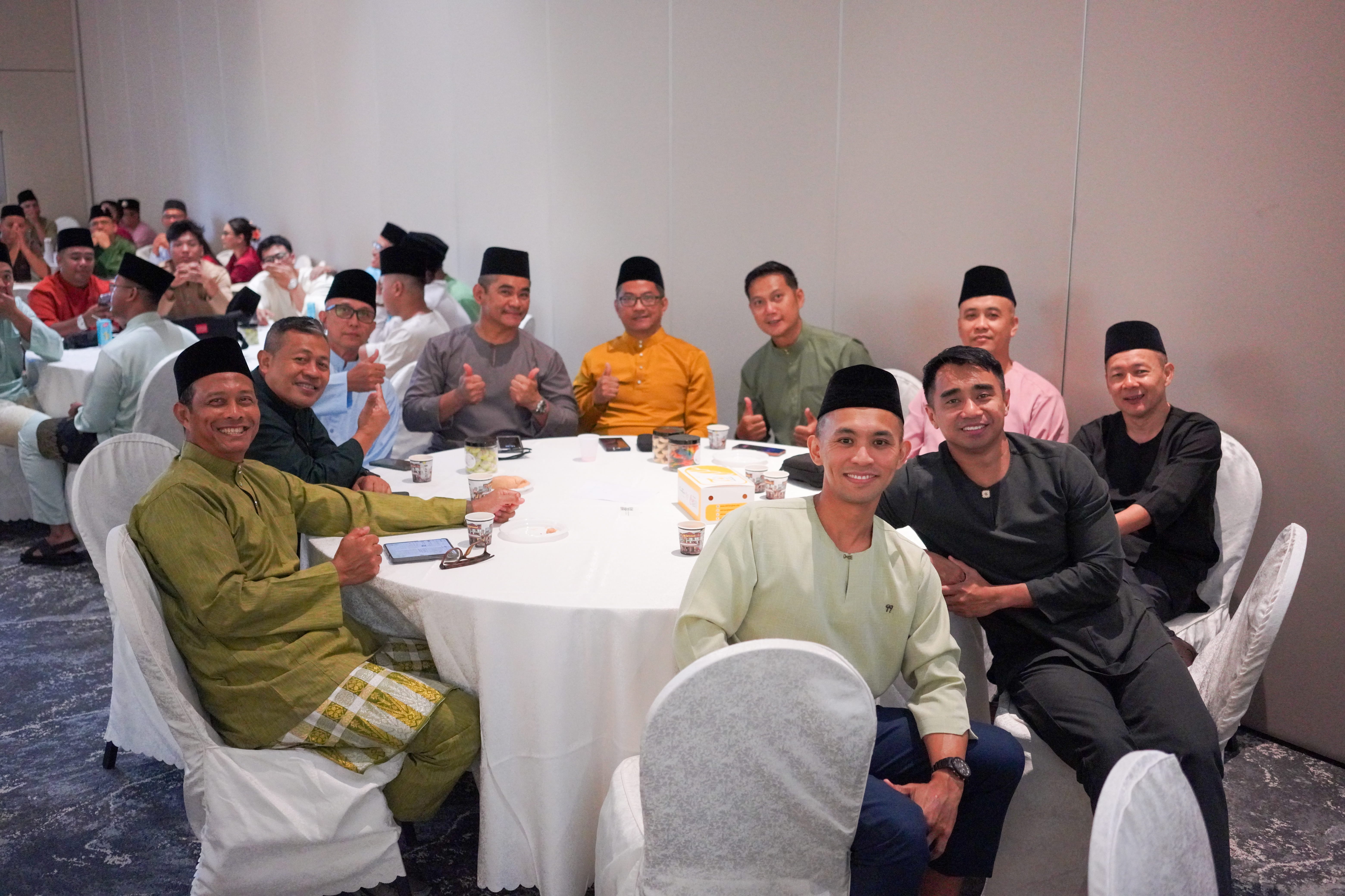 Guests seated together at a table posing for a photograph before the start of the programme.